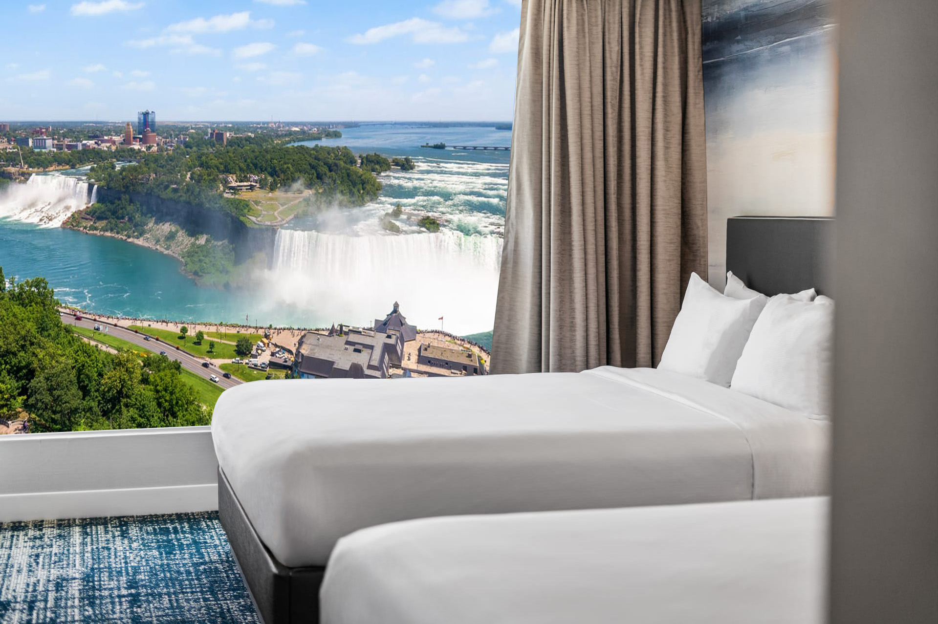 King bed in a bright room with modern blue wallpaper, grey headboard featuring built-in lamps and bedside tables.